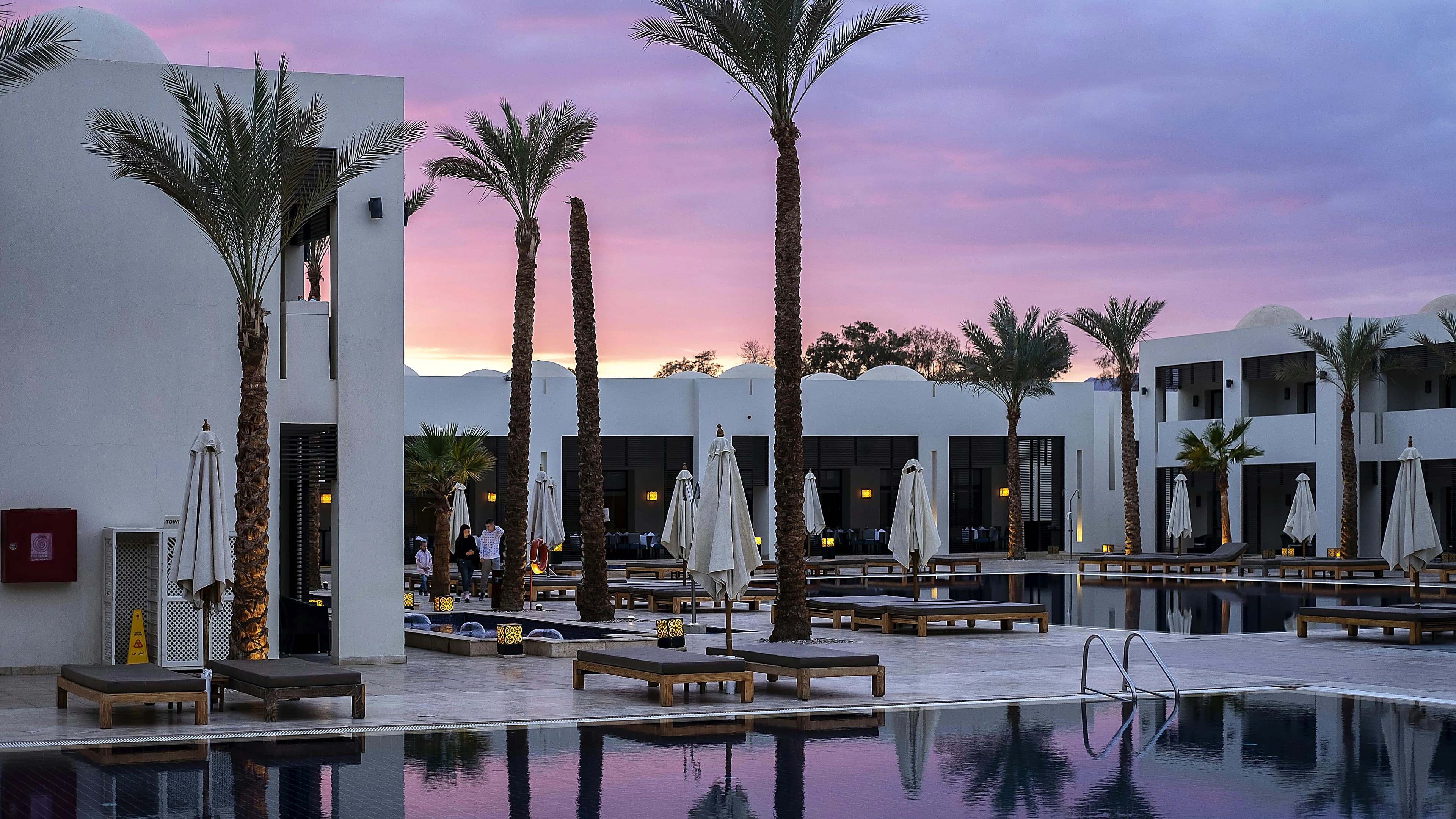 A poolside hospitality scene at sunset
